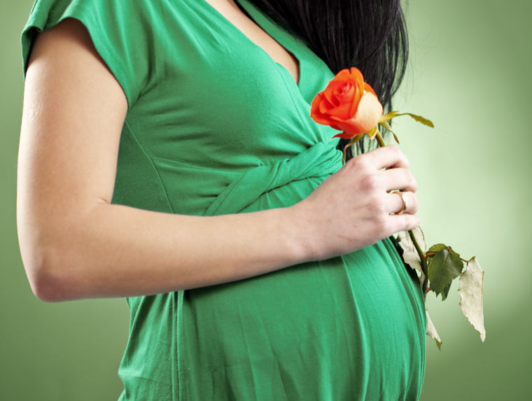Schwangere Frau mit Rose