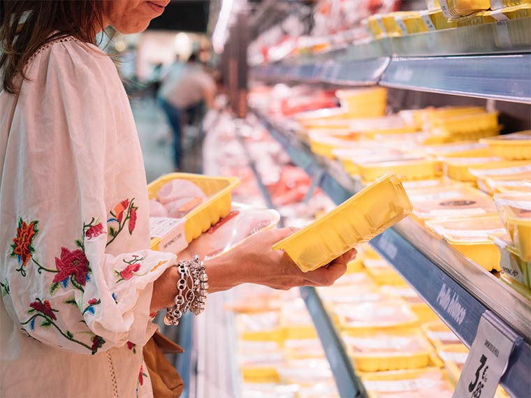 Frau kauft Supermarkt-Fleisch