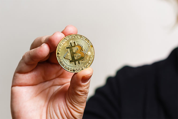 Frau hält Bitcoin in der Hand