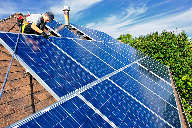 Mann installiert Photovoltaik-Sonnenkollektoren auf Dach